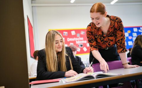 Teacher assisting student with her school work