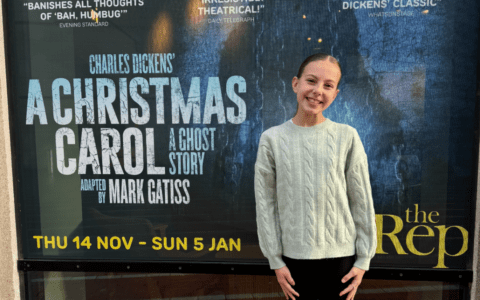 Student stood in front of A Christmas Carol A Ghost Story poster