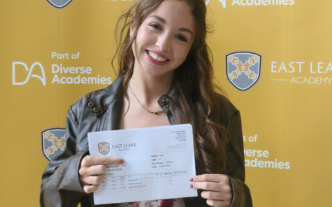Female student smiling holding A level results