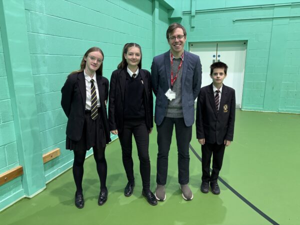 Three students stand with local MP
